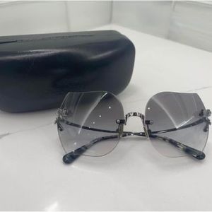 Coach women’s sunglasses with light blue lenses and silver roses on lense